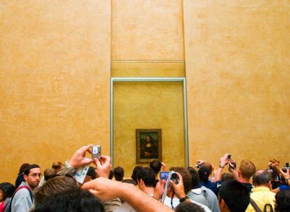 Tourist attraction. Mona Lisa at the Louvre, surrounded by adoring fans. Photo: blog.2modern.com